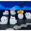 A set of seven cute luminous ghost resin ornaments in various shapes and colors against a dark background.
