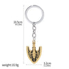 A gold-colored arrow metal keychain with a circular ring and a decorative anchor design.