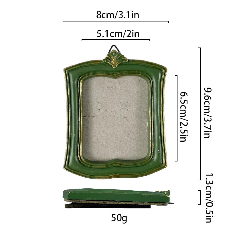A vintage green resin picture frame with a decorative border and a rectangular opening.