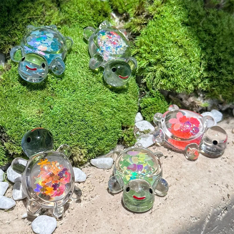 A collection of glow-in-the-dark mini sea turtle figurines resting on moss and small stones.