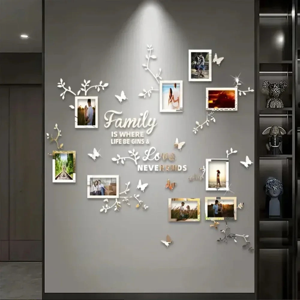 A gray wall decorated with white acrylic mirror tree decals and framed photos, featuring a family theme.
