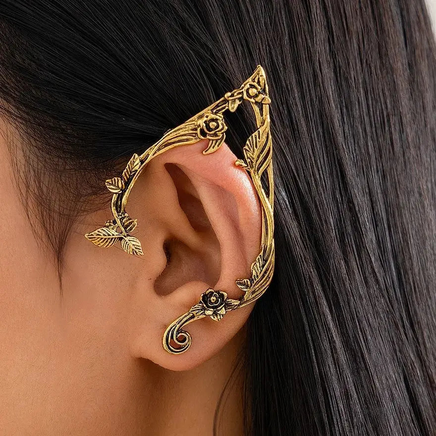 Gold elf flower leaf clip earrings worn on a woman's ear.