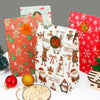 A collection of red and green Christmas kraft paper gift bags decorated with festive stickers and holiday themes.