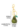 Gold-colored pear-shaped fruit keychain charm with a green glitter finish