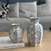 A hand-painted blue and white porcelain vase set displayed on a wooden surface.