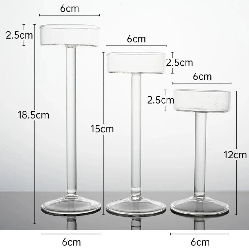 Three clear crystal glass candle holders of varying heights and diameters shown against a white background.
