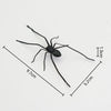 A black realistic spider magnet with outstretched legs shown against a white background.