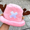 A pink knit cap plush toy resembling Tony Tony Chopper with brown ears and a white cross design