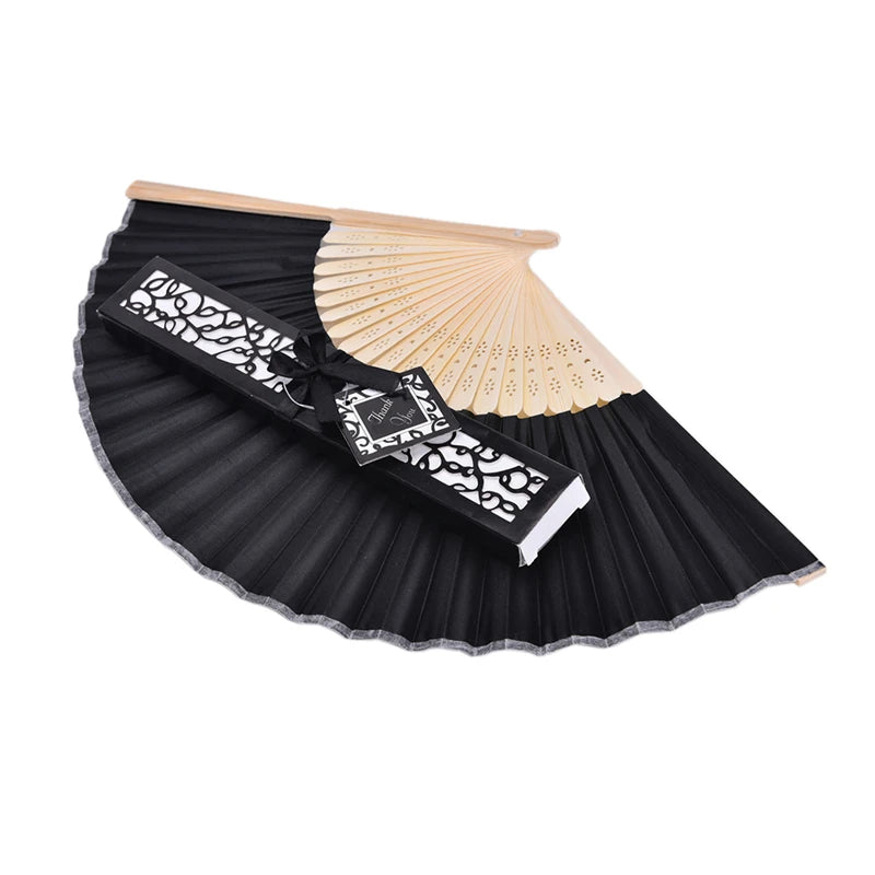 A black folding fan with a decorative black and white pattern and a light bamboo fan attached.