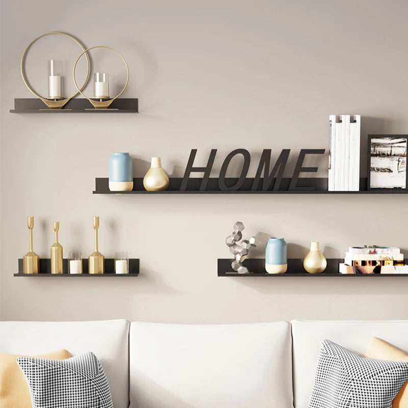 A display of floating metal wall shelves in black and gold holding various decorative items.