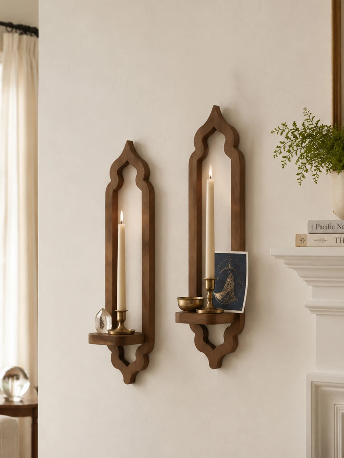 A rustic wooden wall shelf with an arched design holds two lit candles and a small decorative item.