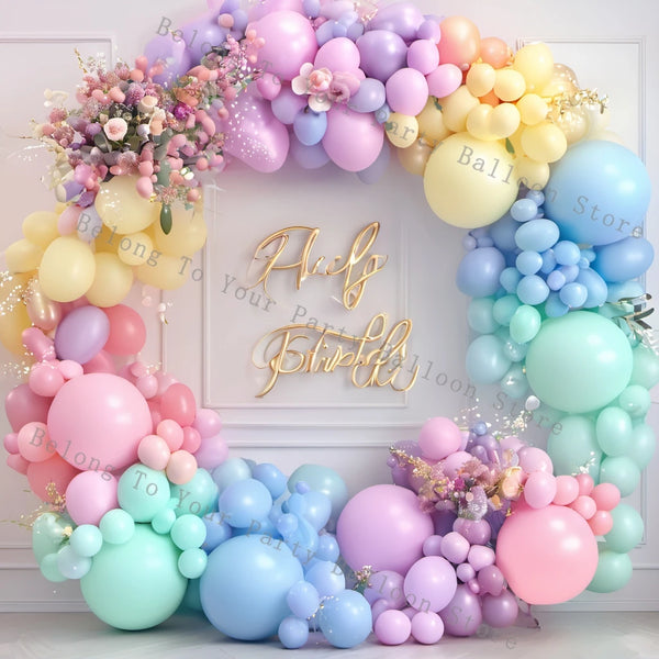 A balloon garland arch kit featuring pastel pink, purple, yellow, and blue balloons for parties