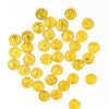 A collection of small, round gold coin party favors arranged in a starburst pattern.