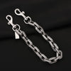 A silver and gold two-tone metal chain necklace with a pendant resting on a black background.