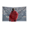 A man wearing a red jacket stands in a stadium setting.