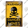 Vintage metal warning sign with yellow background and black text reading WARNING DANGER MINES