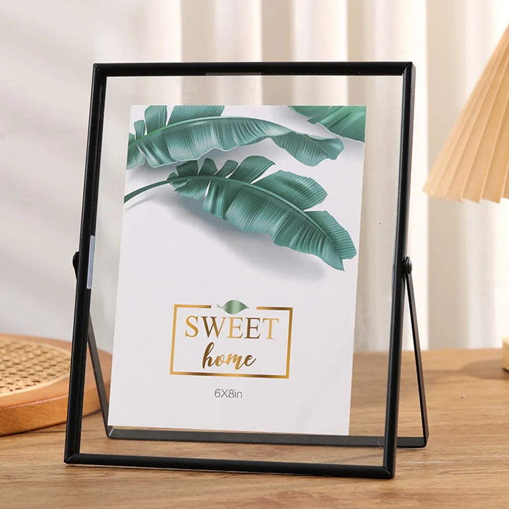 A black photo frame displays a green tropical leaf design with the text Sweet home on a white background.