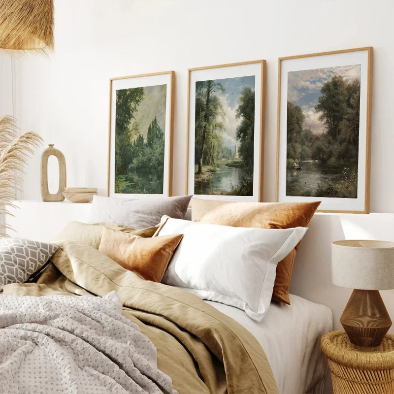 Three framed landscape paintings of trees and water art displayed on a white wall.
