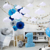 Cloud felt hanging decorations for a birthday party featuring white and blue clouds on a brick wall