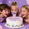 Three children smiling around a white birthday cake decorated with purple and pink frosting and glitter.
