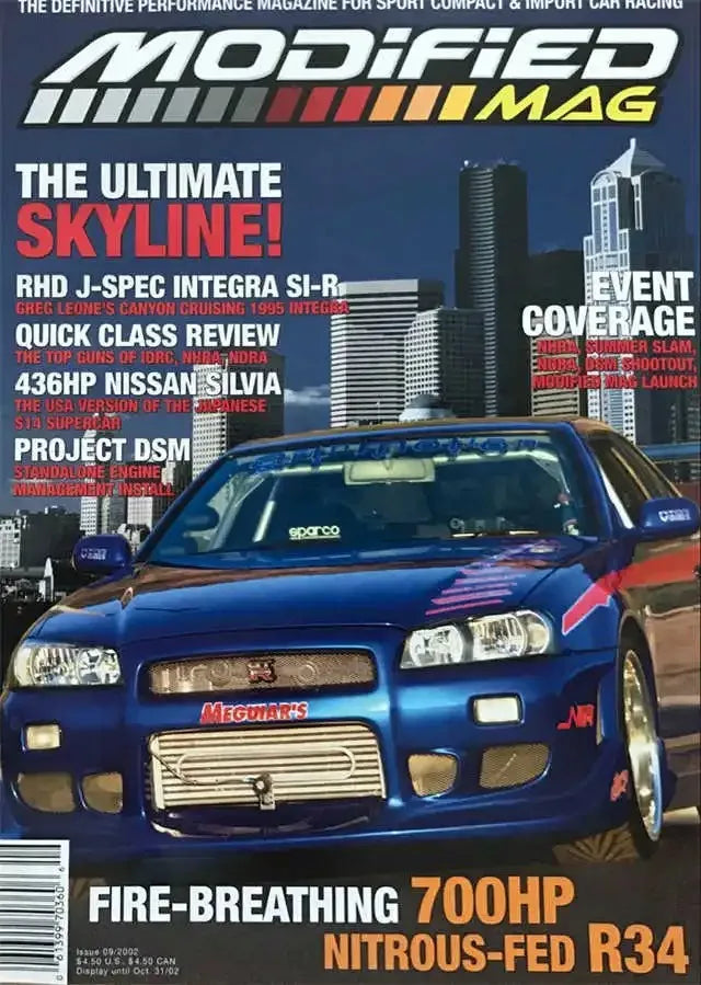 A blue Nissan Skyline car with a modified front bumper and racing decals, featured on a magazine cover.