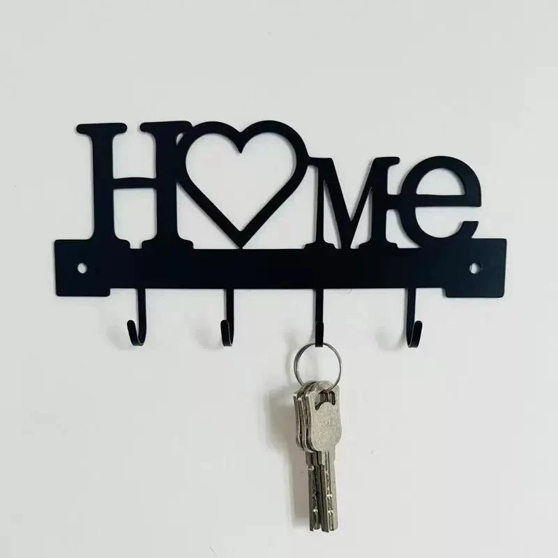 Black letter-shaped metal wall key holder with four hooks, shaped like the word Home.