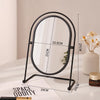 A black oval vanity mirror with a rotating frame and a white background.