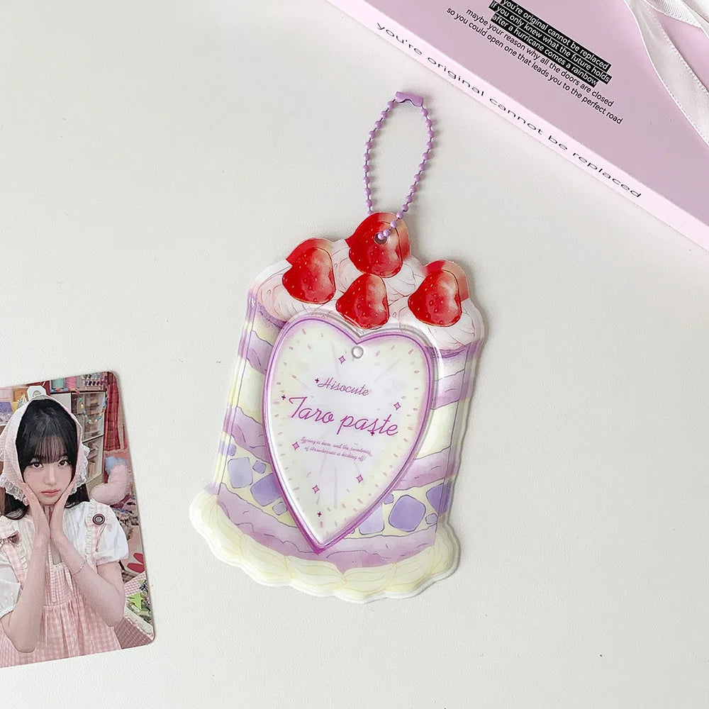 A pink and white cartoon strawberry bag keychain card holder with a heart design and dangling charm.