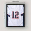 A framed white sports jersey with the number 12 and navy blue trim, displayed in a black frame.