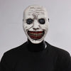 A white demon mask with a wide, menacing grin and red teeth displayed on a black mannequin.