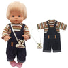 A blonde doll wearing a striped shirt and denim overalls with a small bear charm.
