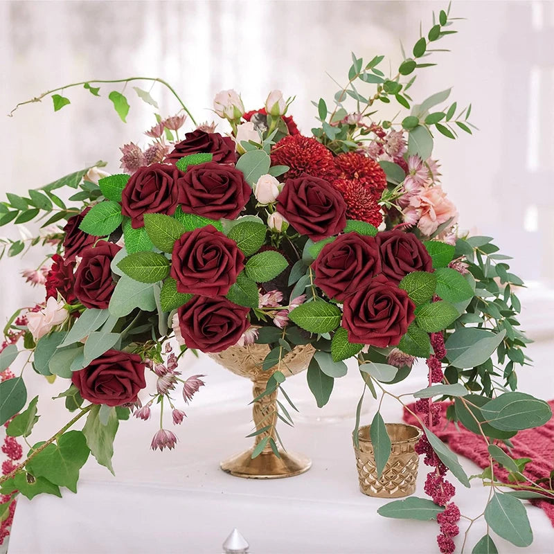 A lush arrangement of deep red and pink foam rose flowers with greenery and filler flowers.
