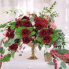 A lush arrangement of deep red and pink foam rose flowers with greenery and filler flowers.