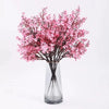 A bouquet of pink cherry blossom and gypsophila artificial flowers displayed in a clear glass vase.