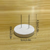 A white circular object with two thin metal pins is shown on a wooden surface, measuring 5cm in diameter and 4.5cm high.