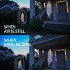 A glowing white ghost decoration hangs on the exterior of a house during twilight, contrasting with the wooden door and archi
