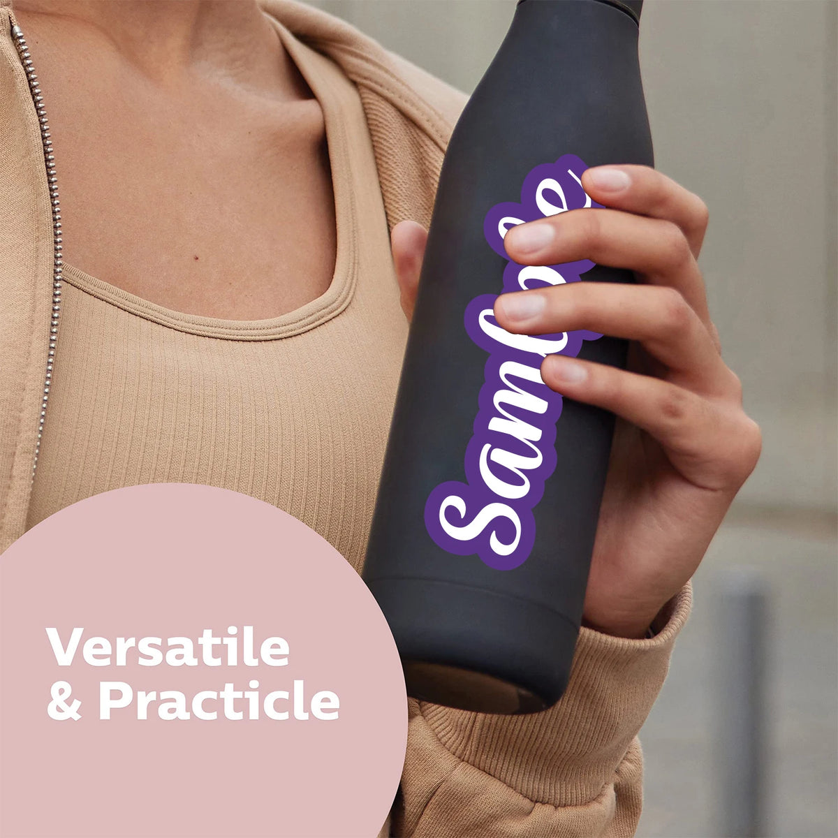 A person holds a black bottle with purple text and a light brown top, demonstrating versatile and practical use.