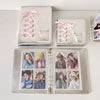Silver leather photo album with pink ribbon ties displaying various collectible photos.