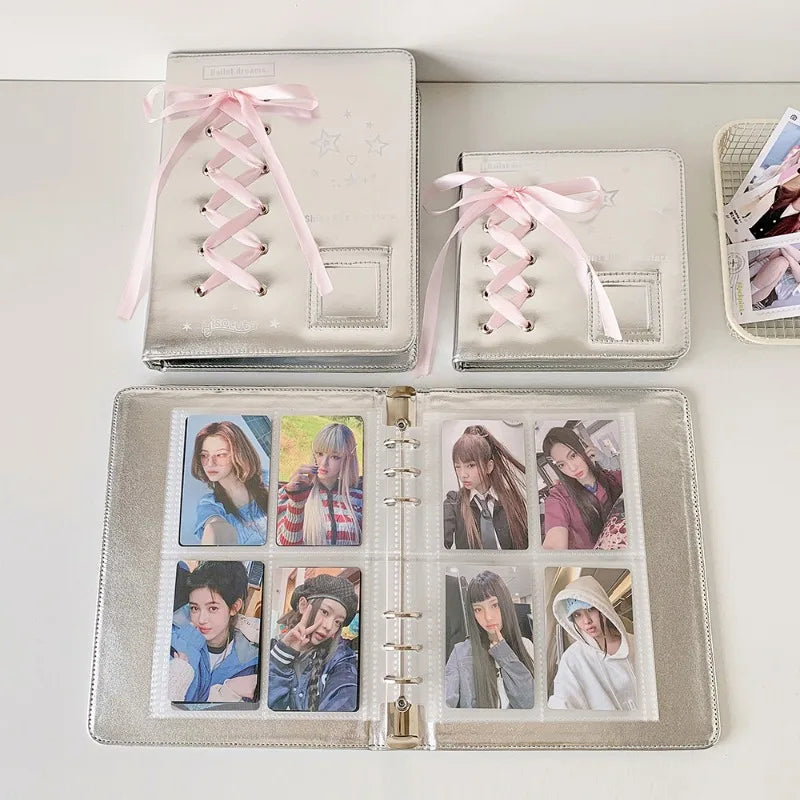Silver leather photo album with pink ribbon ties displaying various collectible photos.