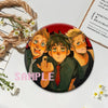 A set of collectible button pins featuring characters from a punk band album cover.
