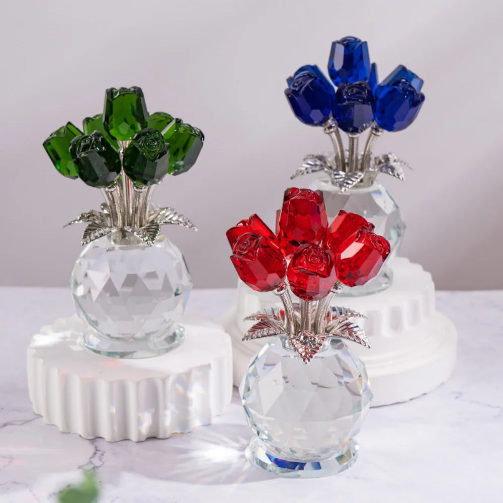 A display of crystal rose decorative flowers in shades of green and blue on white pedestals.