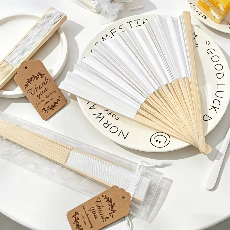 A set of bamboo folding fans with calligraphy text on them displayed on a white surface.
