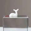 A white resin ornament of an elk or deer head is displayed on a clear glass block.