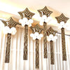 A display of leopard print star balloons with white fluffy accents hanging from a curtain backdrop.