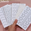 A hand holds several sheets of glitter gem stick-on facial tattoos featuring various heart and star patterns.