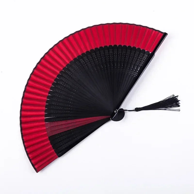 A traditional Chinese folding fan with red and black pleated paper for dance and decor.