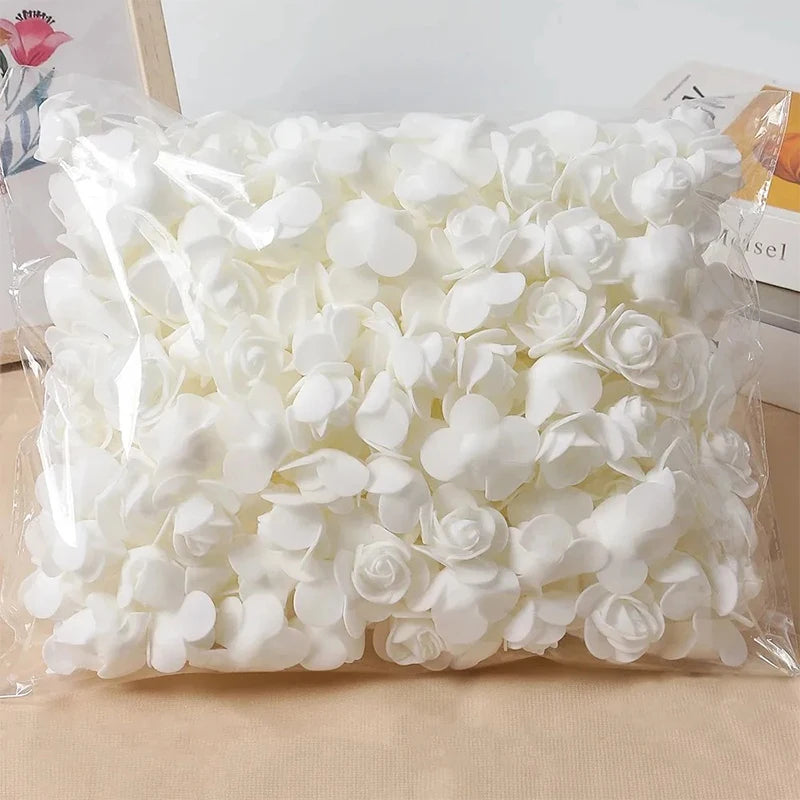 Bolsa de plástico transparente llena de decoraciones de espuma de rosas artificiales blancas.