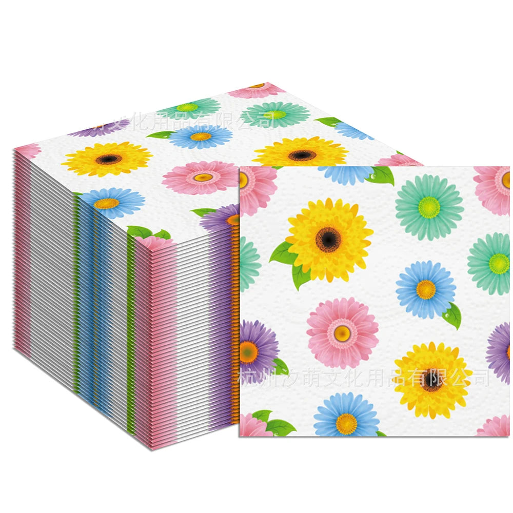 A stack of disposable pink daisy flower napkins featuring colorful floral patterns.