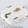 A stack of a 6 inch 100 photos album featuring a white cover with green cactus designs.