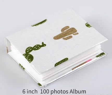 A stack of a 6 inch 100 photos album featuring a white cover with green cactus designs.